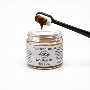 Nano-hydroxyapatite toothpaste on a toothbrush above its glass jar