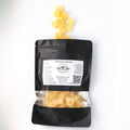 Rich Ginger xylitol mints spilling from an Ora Flora pouch