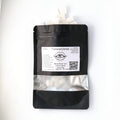 Sweet Mint xylitol mints spilling from an Ora Flora pouch