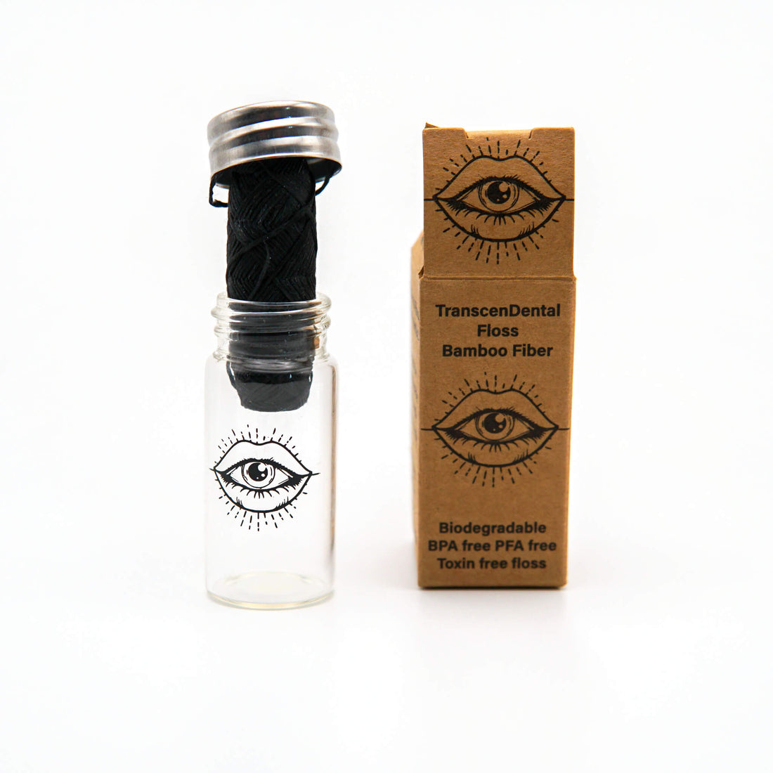 TranscenDental charcoal bamboo floss in its glass jar beside the kraft box